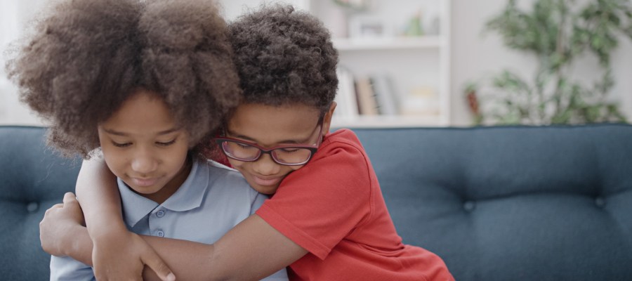 A little boy hugs another child
